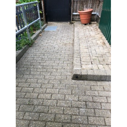 A clear and tidy paved area with no weeds growing between the bricks.